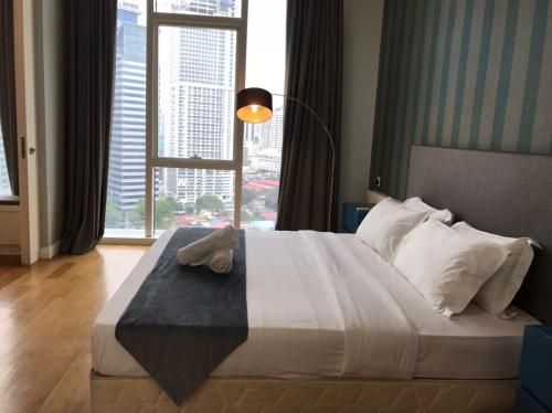 a bedroom with a large bed with a large window at KLCC Sky Villa Suites Platinum in Kuala Lumpur
