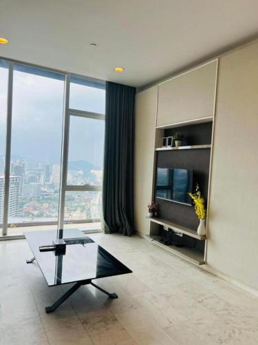 a living room with a table and a television at KLCC Sky Villa Suites Platinum in Kuala Lumpur
