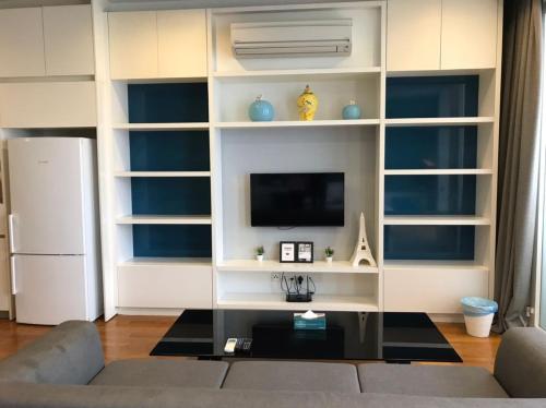 a living room with a couch and a tv at KLCC Sky Villa Suites Platinum in Kuala Lumpur