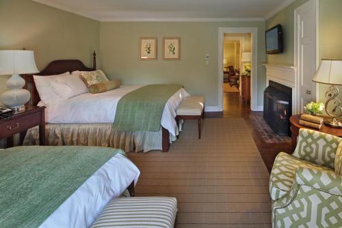 a hotel room with two beds and a fireplace at Inn on Boltwood in Amherst