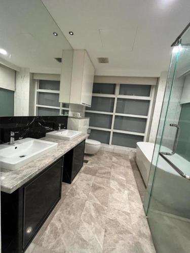 a bathroom with two sinks and a toilet and a shower at KLCC Sky Villa Suites Platinum in Kuala Lumpur