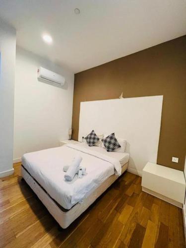 a bedroom with a large white bed with two pillows at KLCC Sky Villa Suites Platinum in Kuala Lumpur