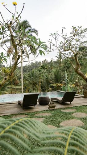 a bath tub sitting in a garden with trees at Sebatu Tulen Villa in Tegalalang