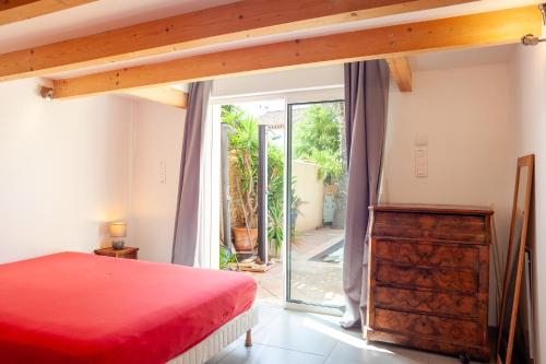 - une chambre avec un lit rouge et une porte coulissante en verre dans l'établissement Villa kitesurf 350m plage de sable, à Six-Fours-les-Plages