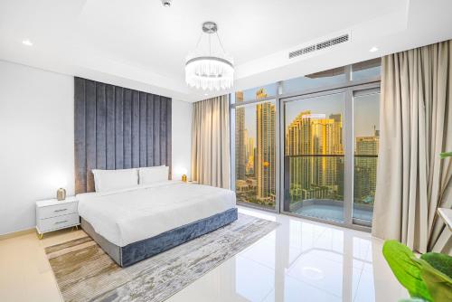 a bedroom with a white bed and a large window at Paramount Hotel Apartment Midtown - Platinium Dubai in Dubai