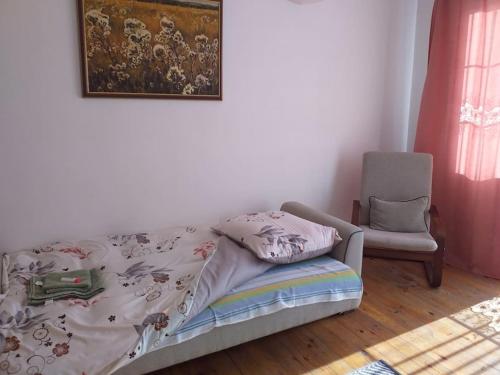 a bedroom with a bed and a chair and a picture at zielone Bemowo zaprasza in Warsaw