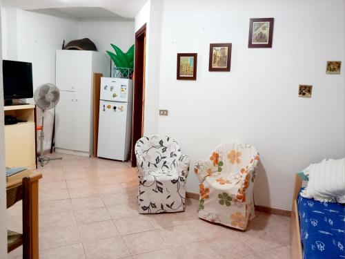 2 sillas en una sala de estar con nevera en Pinna1 - Appartamento in villetta in pineta - IUN R4823, en S'Archittu