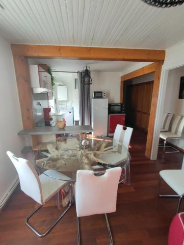 une salle à manger avec une table et des chaises blanches dans l'établissement le Cozy Nest, à Gérardmer
