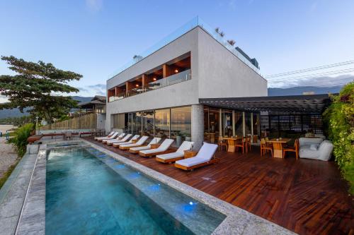 una casa con piscina y tumbonas en Duke Beach Hotel Maresias, en Maresias