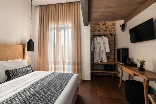 a bedroom with a bed and a desk and a television at Kera Neme in Neméa