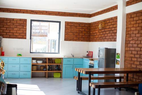 uma cozinha com armários azuis e uma parede de tijolos em Mountain View Town House em Iringa