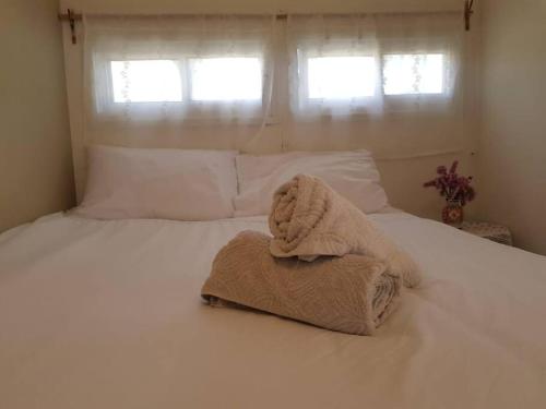 uma toalha sentada em cima de uma cama branca em פינה מתוקה בעמק החולה em Yesud HaMa‘ala
