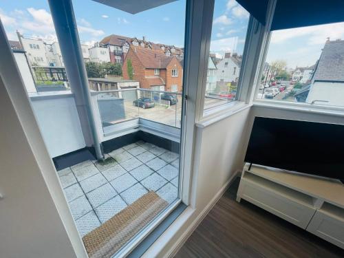 um quarto com uma janela com vista para uma varanda em Leigh On Sea - Prime Location! Ultra Modern Entire Apartment With Free Gated Parking & Private Balcony em Southend-on-Sea