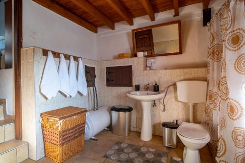 ein Badezimmer mit einem Waschbecken, einem WC und einer Badewanne in der Unterkunft Billy's Stonehouse in Samos