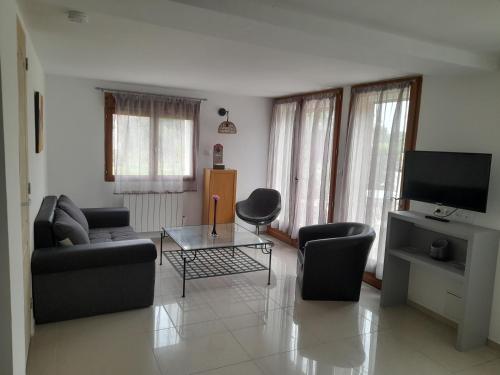 un salon avec un canapé et une table dans l'établissement Appartement passion climatisé du Domaine d'Alzira, à Maisse