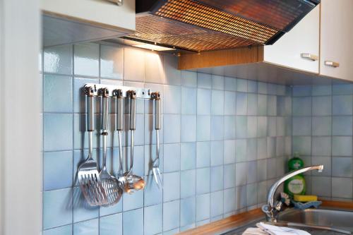 a kitchen with utensils hanging on a tiled wall at Fewo 3 Haus am Lärchenhang in Leutasch