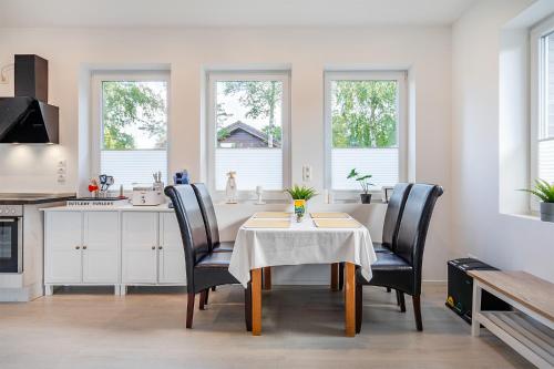 a dining room with a table and chairs in a kitchen at Haus am See, exquisites Relaxen in Südbrookmerland