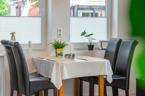 a table with black chairs and a white table cloth at Haus am See, exquisites Relaxen in Südbrookmerland