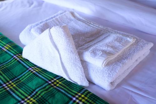 two white towels sitting on top of a bed at Emunyan Mara Camp in Narok