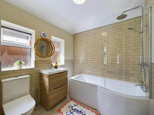 a bathroom with a tub and a toilet and a sink at Stones Throw - stunning house, mins from beach and dogs welcome in Broadstairs