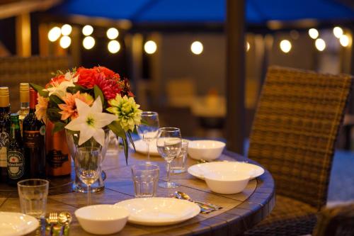 a table with a vase of flowers and wine glasses at MIYABI Highland Terrace Villa B in Fujiyoshida