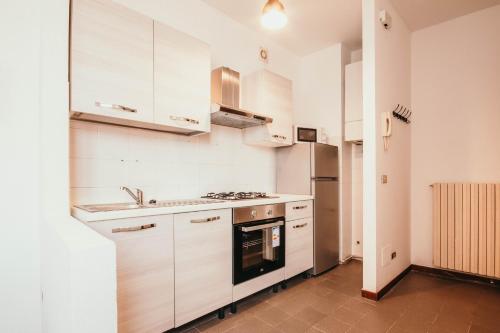 a kitchen with white cabinets and a stove at Appartamento Cairoli - Affitti Brevi Italia in Varese