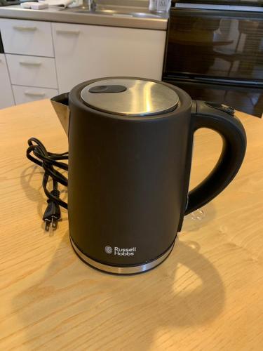 a black coffee mug sitting on top of a table at NIYS apartments 01 type in Tokyo