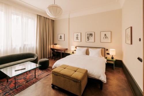ein Schlafzimmer mit einem Bett, einem Stuhl und einem Sofa in der Unterkunft Boutique Hotel Château Royal in Berlin