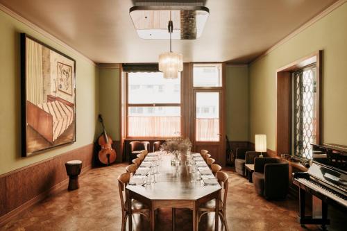 a dining room with a table and a piano at Boutique Hotel Château Royal in Berlin
