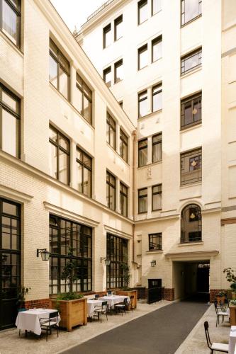 an empty courtyard of a building with tables and chairs at Boutique Hotel Château Royal in Berlin