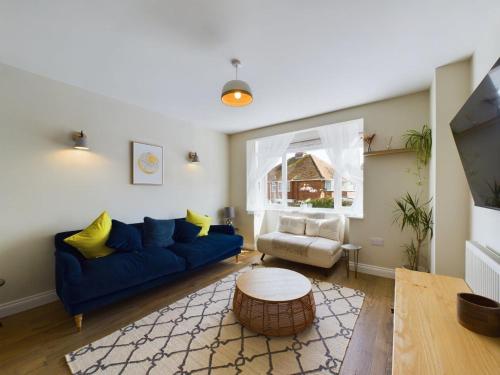 a living room with a blue couch and a table at Stones Throw - stunning house, mins from beach and dogs welcome in Broadstairs