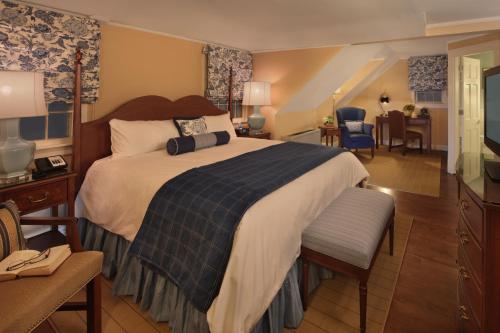 a bedroom with a large bed and a living room at Inn on Boltwood in Amherst