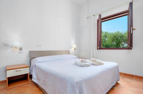 1 dormitorio con 1 cama con 2 toallas en Appartamento Le Palme Costa Smeralda en Arzachena