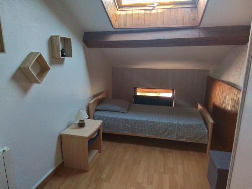 une petite chambre avec un lit et une fenêtre dans l'établissement MAISON DE VILLAGE ST MARCELLIN, à Veynes