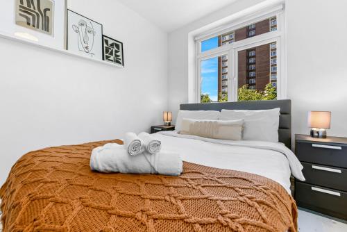 sypialnia z dużym łóżkiem z dwoma ręcznikami w obiekcie Finsbury Park Station Apartment! (B) w Londynie