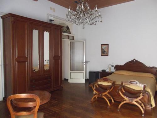 a bedroom with a bed and chairs and a chandelier at Hotel La Vela-Castello Il Rifugio in Santa Margherita Ligure