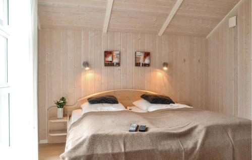a bedroom with a large bed with two pillows at Cozy Home In Hvide Sande With Kitchen in Havrvig