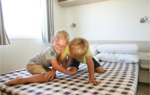 ヴィデ・サンデにあるAwesome Home In Hvide Sande With 2 Bedrooms, Wifi And Indoor Swimming Poolの小さな子供2人がベッドで遊んでいる