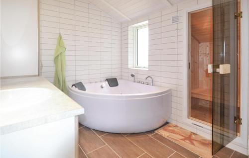 ヴィデ・サンデにあるAwesome Home In Hvide Sande With 4 Bedrooms, Sauna And Wifiの白いバスルーム(バスタブ、シャワー付)