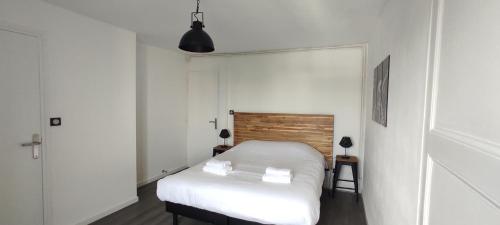 Cette petite chambre comprend un lit avec des draps blancs. dans l'établissement Les temps modernes, à Boulogne-sur-Mer