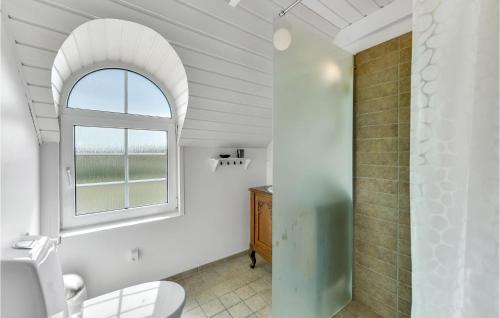 KlegodにあるNice Home In Ringkbing With Saunaのバスルーム(トイレ付)のアーチ型の窓