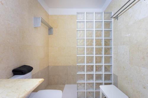 a bathroom with a toilet and a glass block wall at Home2Book Charming Studio Santa Cruz City Views in Santa Cruz de Tenerife