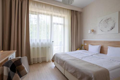 1 dormitorio con cama y ventana grande en Helios, en Bukovel