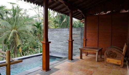 a porch of a house with a chair and a pool at Sebatu Tulen Villa in Tegalalang