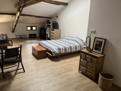 1 dormitorio con 1 cama y suelo de madera en Les chambres du Golf, en Espalais