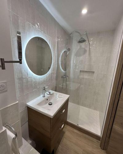 une salle de bain avec une douche, un lavabo et un miroir dans l'établissement Le cap dagde, au Cap d'Agde
