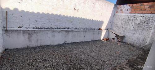 a corner of a white wall with a bench at casa temporada em Barreirinhas in Marinheiros