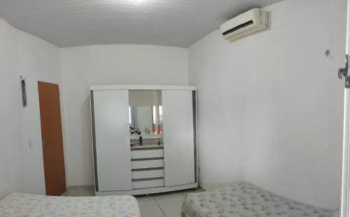 a bedroom with a mirror and a bed in it at casa temporada em Barreirinhas in Marinheiros