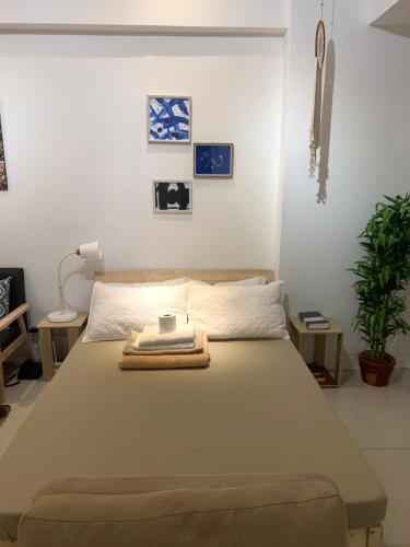 1 dormitorio con 1 cama con toallas en Scandi Minimalist Mckinley Hill BGC en Manila