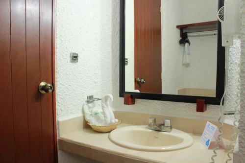 a bathroom with a sink and a mirror at Hotel Antillano in Cancún